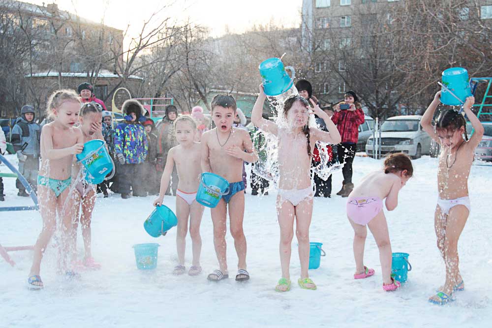 The Russian nursery children standing in the snow, challenge the ice bucket.